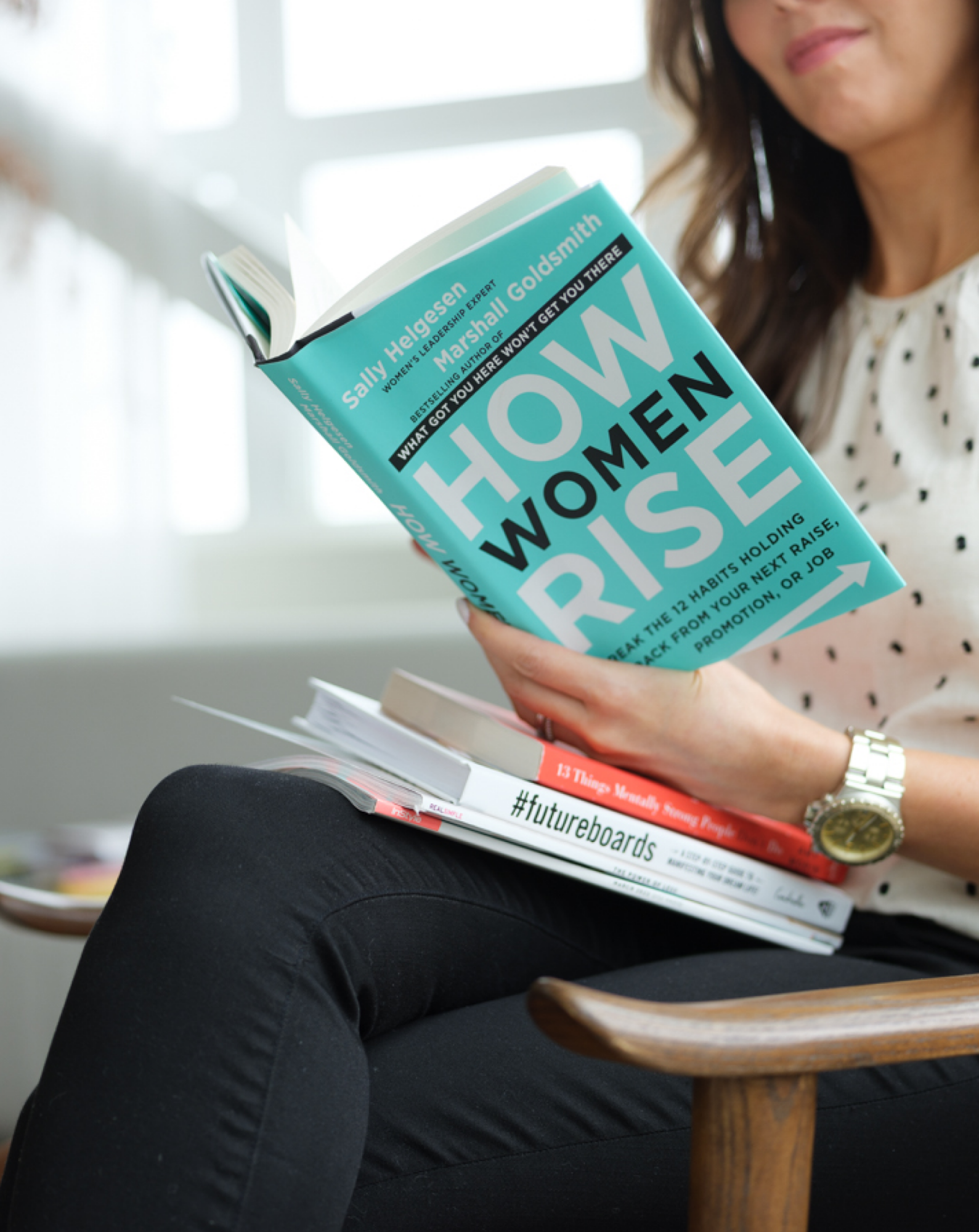 A woman reading How Women Rise for breaking habits and success